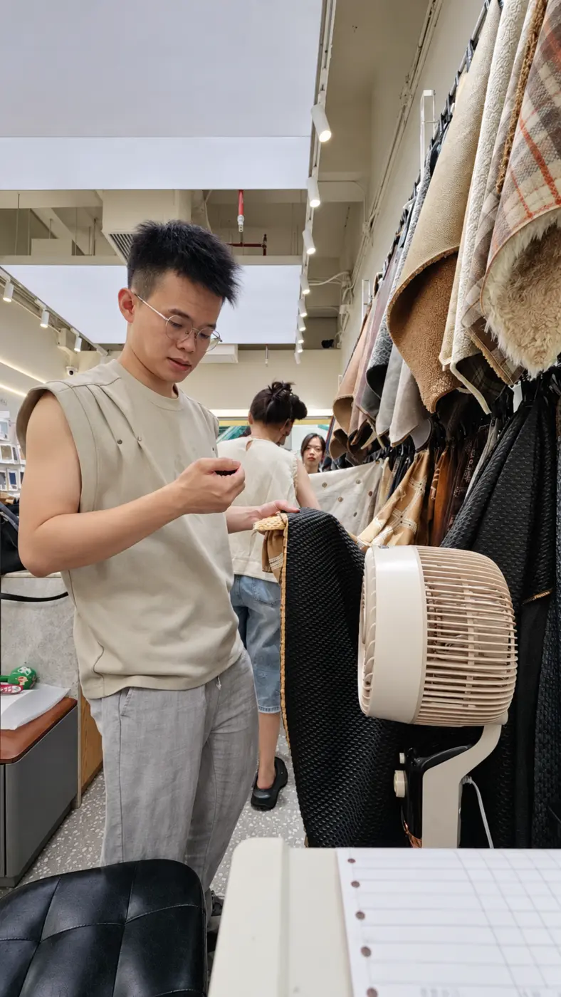 Derrick inspecting textured fabrics at Guangzhou textile market