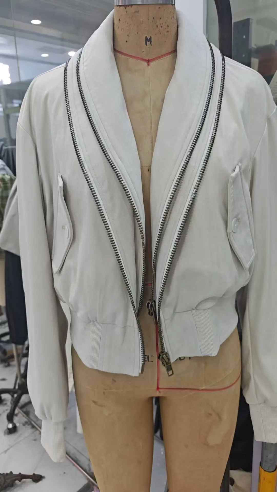Light jacket sample with contrast trim on a dress form