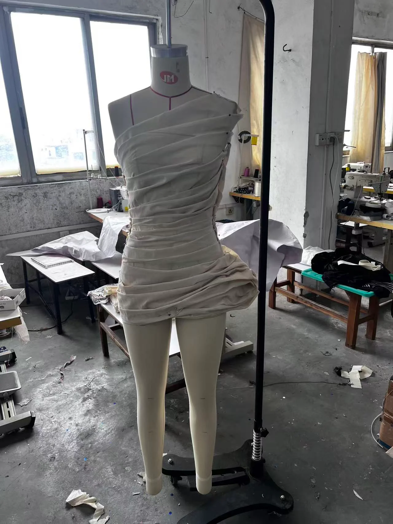 White muslin first toile on a dress form, front angle